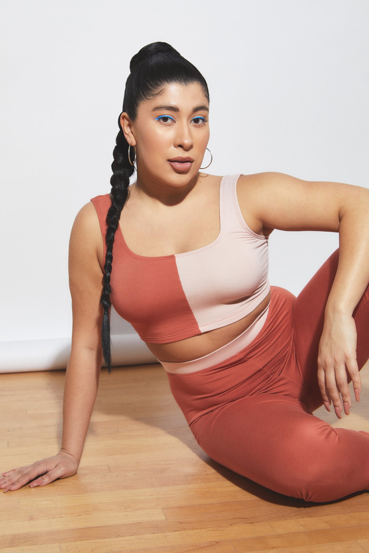 Woman sitting on floor in dual-tone red-pink bralette